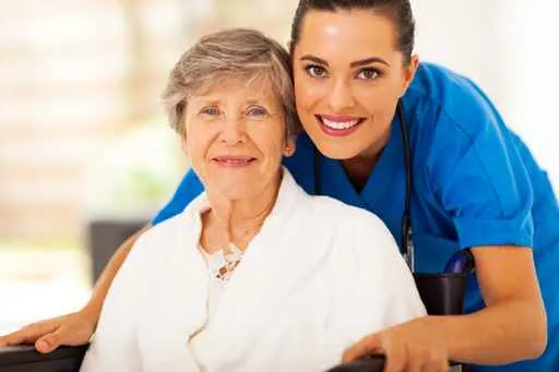 Alzheimer's In-Home Care - happy senior woman on wheelchair with female caregiver
