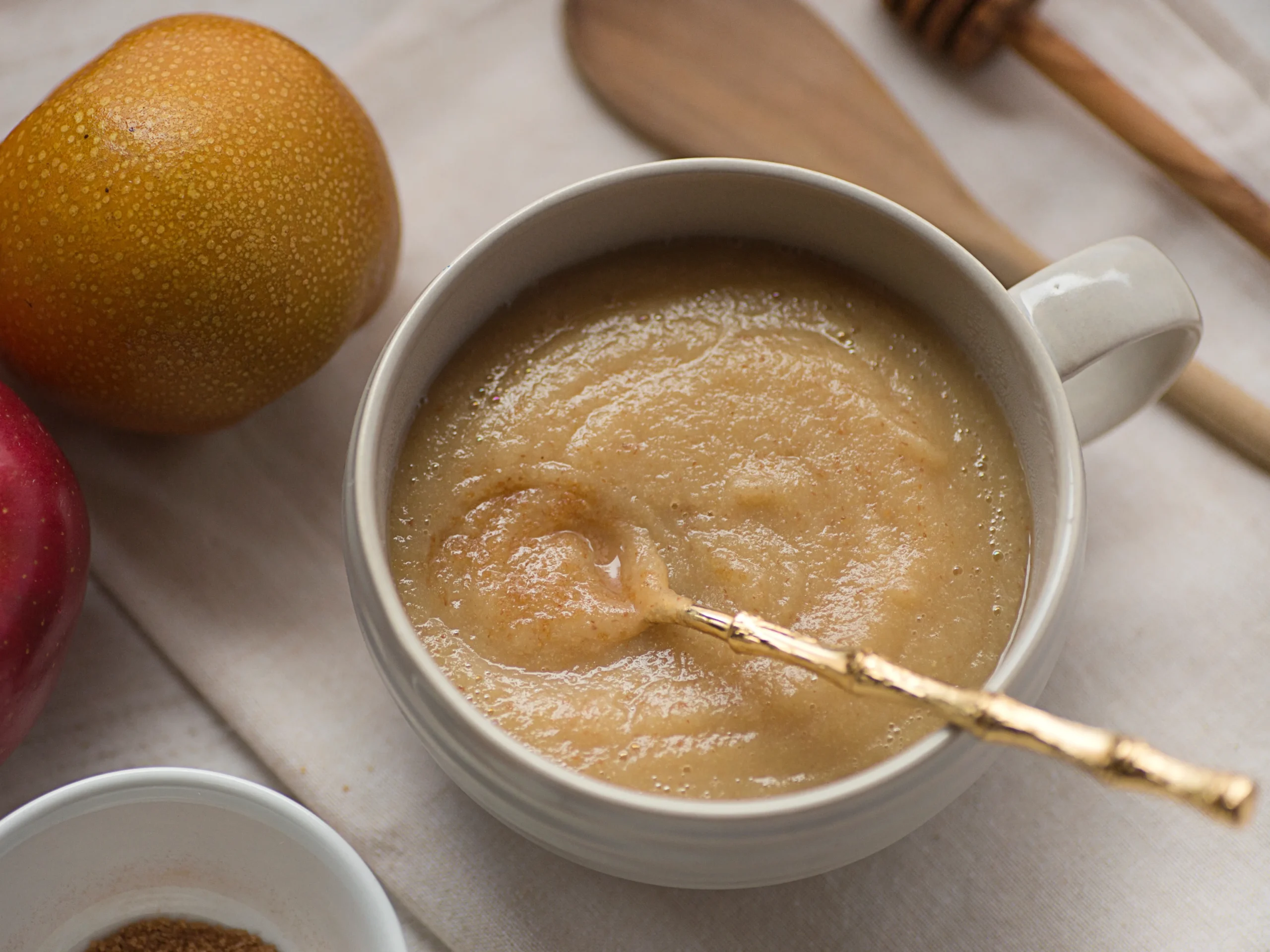 applesauce in a bowl with a gold spoon - one of the soft food ideas for the elderly