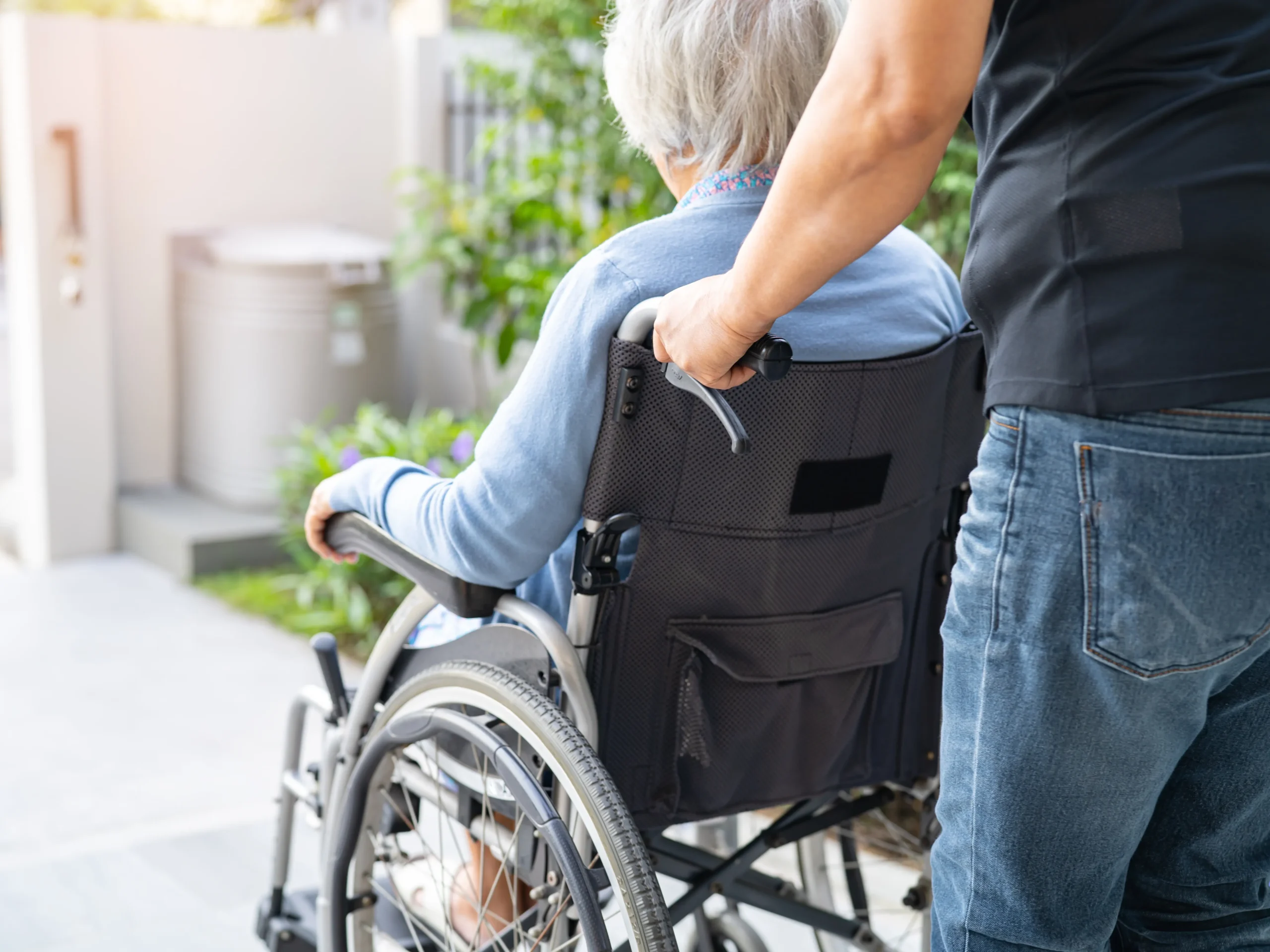 man pushing elderly woman in a wheel chair